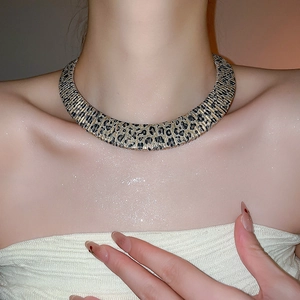 Close-up of leopard print metal choker necklace worn by a model for fashion styling