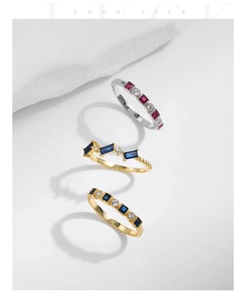 Close-up of three s925 silver rings with colorful gemstones on a white stone background