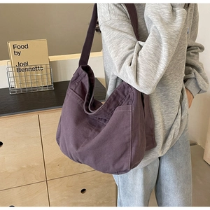 Detail of a large purple canvas tote bag with side pocket and premium texture