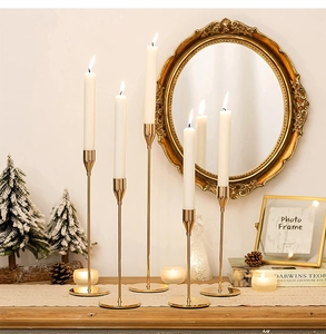 Set of five elegant gold metal candle holders with slim stems in various heights