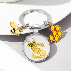 Detail of bee keychain with letter S glass dome charm and pearl bee pendant