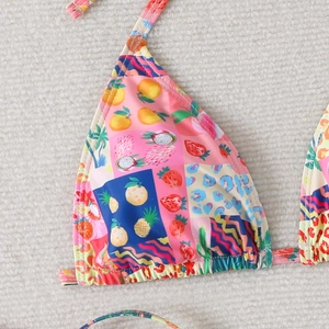 Detailed macro view of bikini top featuring vibrant fruit prints and leopard patterns