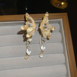 Detailed close-up of butterfly wing earrings with freshwater pearls and crystals