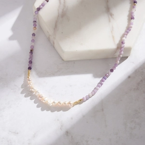 Detailed close-up of natural purple stone beads and white freshwater pearls on a necklace
