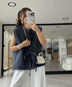 Detail of plush faux fur knit vest in dark blue with a soft textured finish