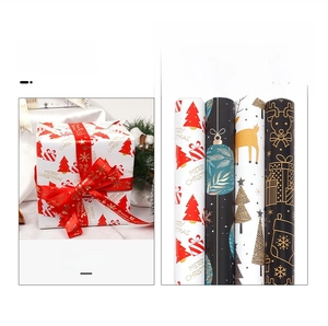 Close-up of festive Christmas wrapping paper rolls featuring reindeer and snowflake patterns