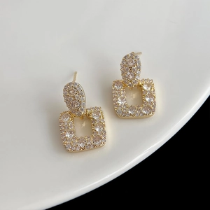 Détail macro de boucles d'oreilles fleur plaquées or avec zircons sur un plat