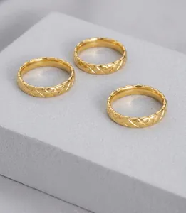 Macro shot of gold quilted textured rings set against a minimalist editorial background