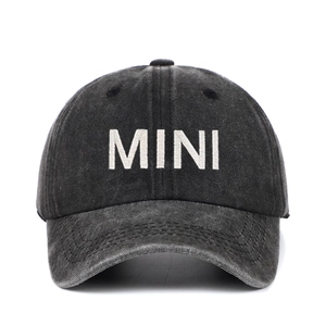 Close-up of white 3D MINI embroidery on washed dark grey cotton baseball cap fabric