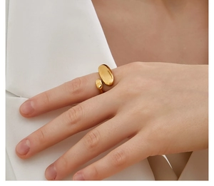 Detail view of gold geometric irregular oval open ring worn on a finger