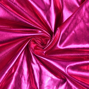 Detail of glossy metallic rose red fabric with stylish pleated texture and vibrant sheen