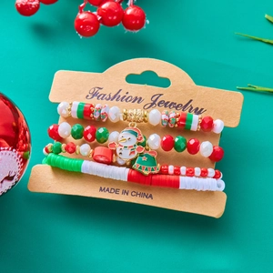 Christmas beaded bracelet set with snowman and bell charms on green festive backdrop