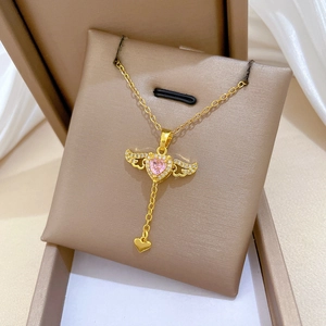 Makroaufnahme der goldenen Herz-Halskette mit rosa Edelstein und Flügeln in einer Box