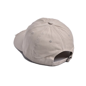 Detail of beige distressed cotton cap showing adjustable metal buckle and frayed edge