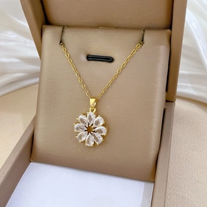 Détail macro du pendentif fleur en zircon rotatif doré champagne sur boîte cadeau