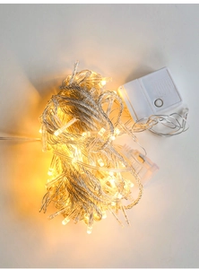 Close-up of warm white LED string lights with a white manual mode controller