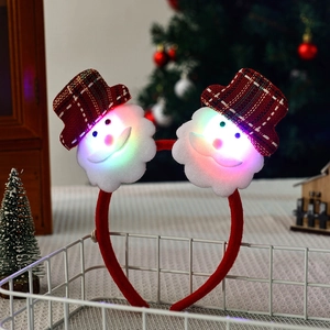 Detail showing glowing snowman headbands with LED lights in a festive basket