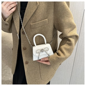 Elegant white mini crossbody bag with rhinestone bow and silver chain strap