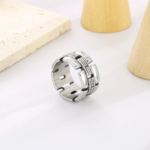 Makro-Detail des silbernen geometrischen Rings auf minimalistischem Stein- und Holzsockel