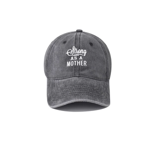 Gros plan sur la texture en coton lavé et le texte Strong AS A MOTHER sur la casquette