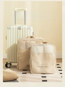 Detail of two beige travel organizer bags with breathable mesh on a white suitcase