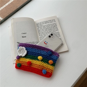 Macro shot of rainbow knit crochet bag with floral patterns on a vintage book