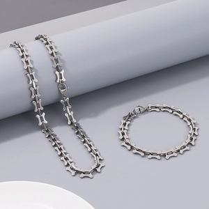 Detail view of silver titanium steel bone link chain necklace and bracelet on grey display
