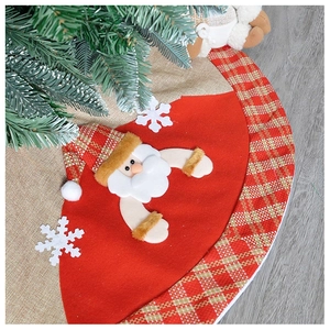 Detailed view of burlap Christmas tree skirt with plush Santa Claus and snowflake motifs