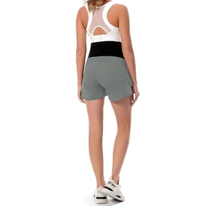 Dettaglio del set sportivo premaman con reggiseno bianco incrociato e pantaloncini grigi