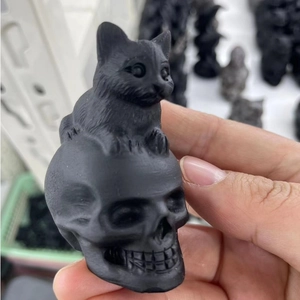 Macro detail of obsidian carving featuring a cat sitting on top of a skull sculpture