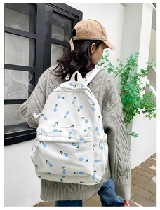 Detail of floral canvas backpack featuring blue tulips and sturdy zipper pockets on a white bag