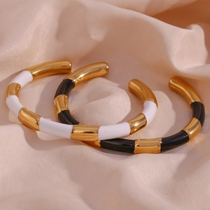 Detail of 18K gold plated C-shaped open bangles with bamboo design and enamel finish