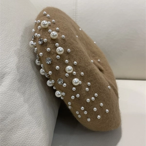 Detailed view of the khaki wool beret featuring elegant pearls and rhinestone accents