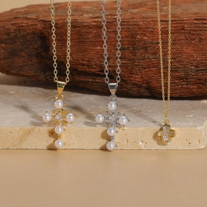 Cross pendant necklace with pearls and zircon on rustic wood and stone background