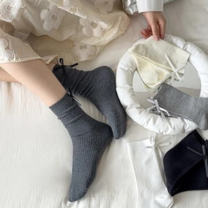 Detail of ribbed cotton mid-calf socks with cute bow accents in various soft colors