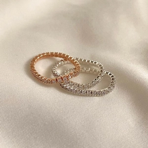 Three stackable cubic zirconia flexible rings in rose gold and silver on silk texture