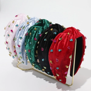Velvet padded headbands with crystals in five colors on a professional gold display stand
