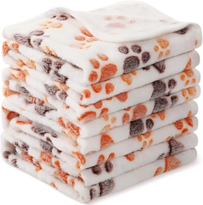 Stacked soft flannel pet blankets with colorful paw prints and reinforced edges