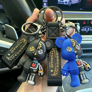 Mechanical style bear keychain with nylon strap in a car interior setting