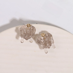 Macro shot of smoky grey resin melting heart pendants with gold metal rings for DIY jewelry