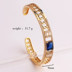 Detail view of gold chain cuff bracelet with blue rectangle zircon and side dimensions
