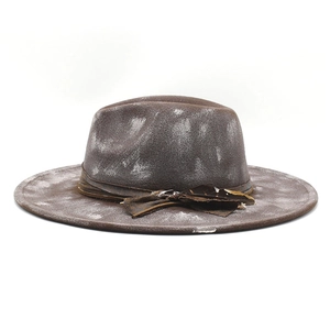 Detailed macro view of distressed wool felt fedora featuring leather band and feather accent