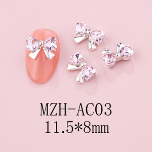 Macro shot of 11.5x8mm bow-shaped nail art charms with pink heart rhinestones