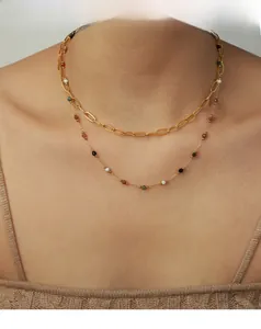 Close-up of double-layer gold geometric necklace with multicolor stones on a model