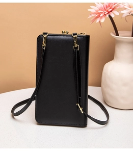 Detail of black leather crossbody phone purse with golden metal clasp on elegant background