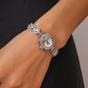 Close-up of a silver floral quartz watch with crystals worn on a woman's wrist