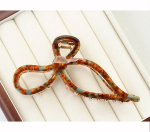 Macro view of a tortoiseshell acetate hair claw with a twisted design in a jewelry box