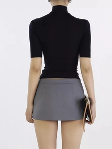 Back view of a slim-fit black high-neck T-shirt paired with a grey mini skirt