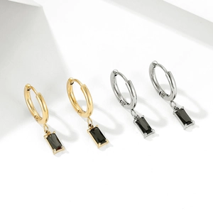 Vintage gold and silver hoop earrings with rectangular black zircon pendants on a white podium