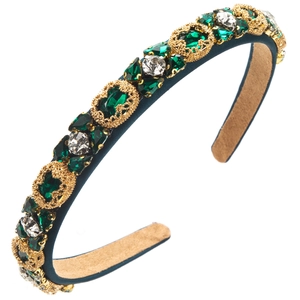Macro detail of luxury baroque headband with green crystals and gold filigree patterns